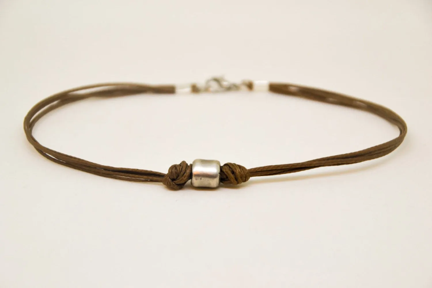 Men's anklet with a silver tube charm and a brown cord, jewelry for man